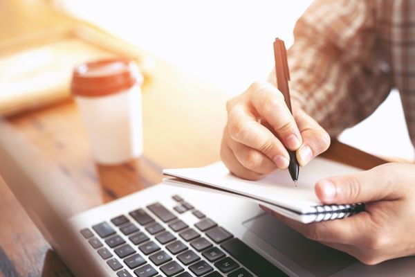 english degree student writing in notebook