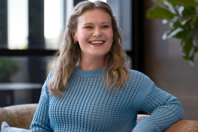 Naomi Parker sitting on a couch smiling