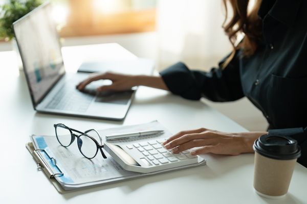 business professional typing on calculator